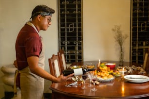 un uomo in piedi a un tavolo con un piatto di cibo e un bicchiere di vino
