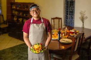 a woman standing in front of a table holding a plate of food