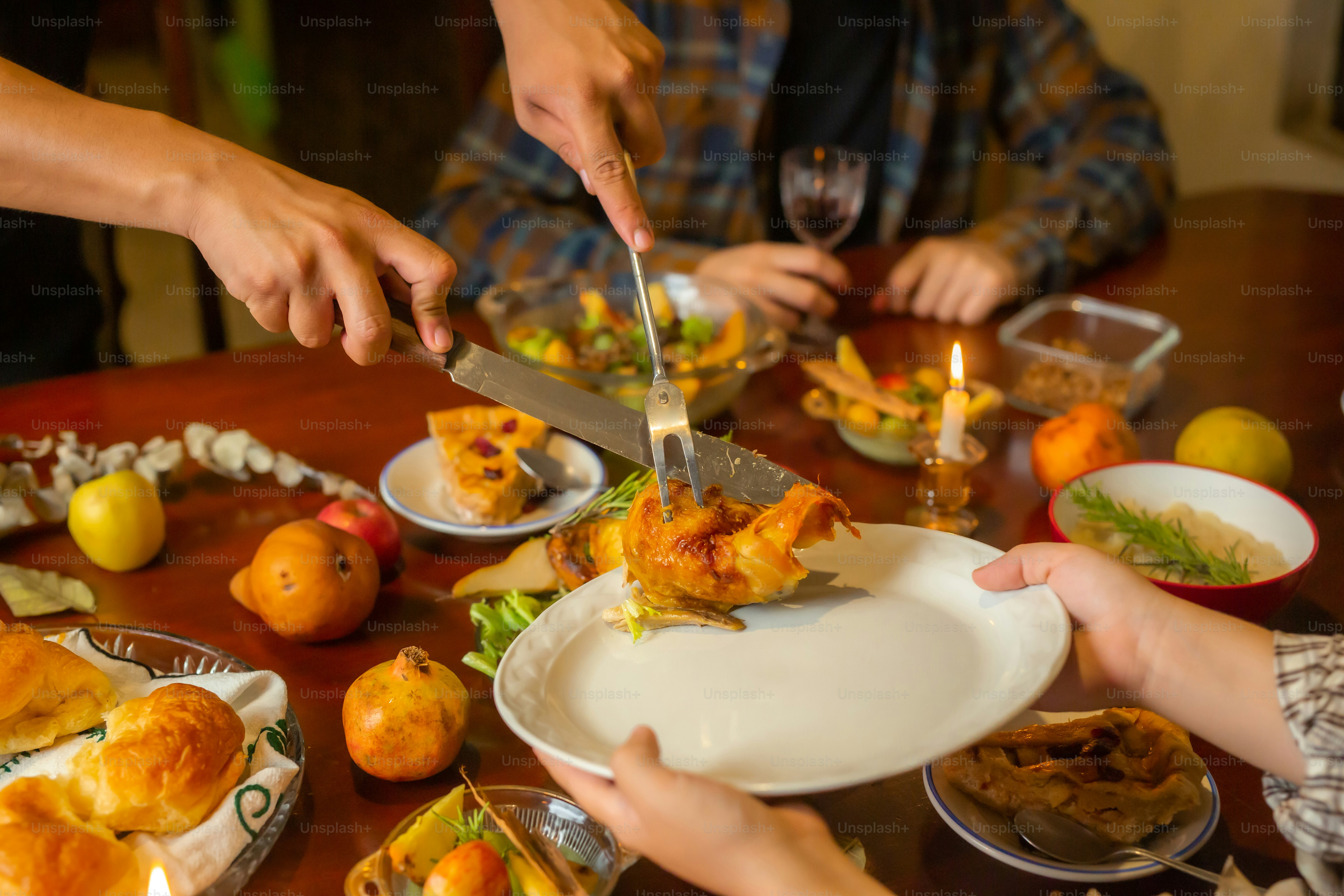 A group of people sitting around a table with plates of food photo ...