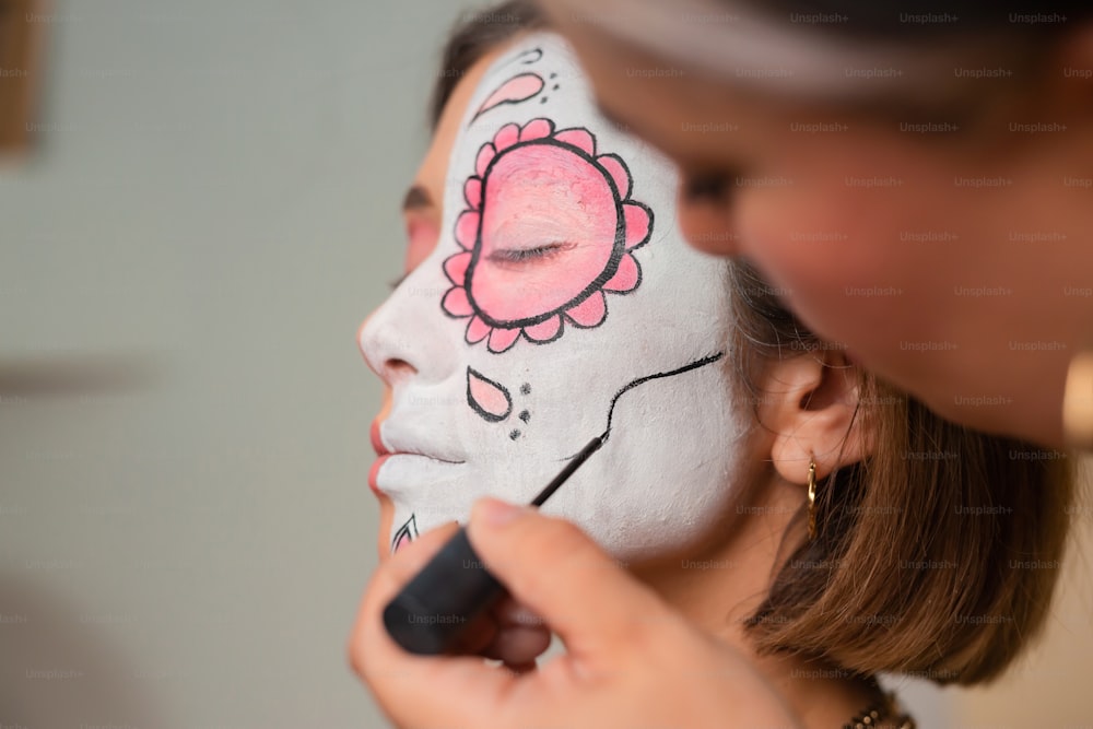 a woman is getting her face painted