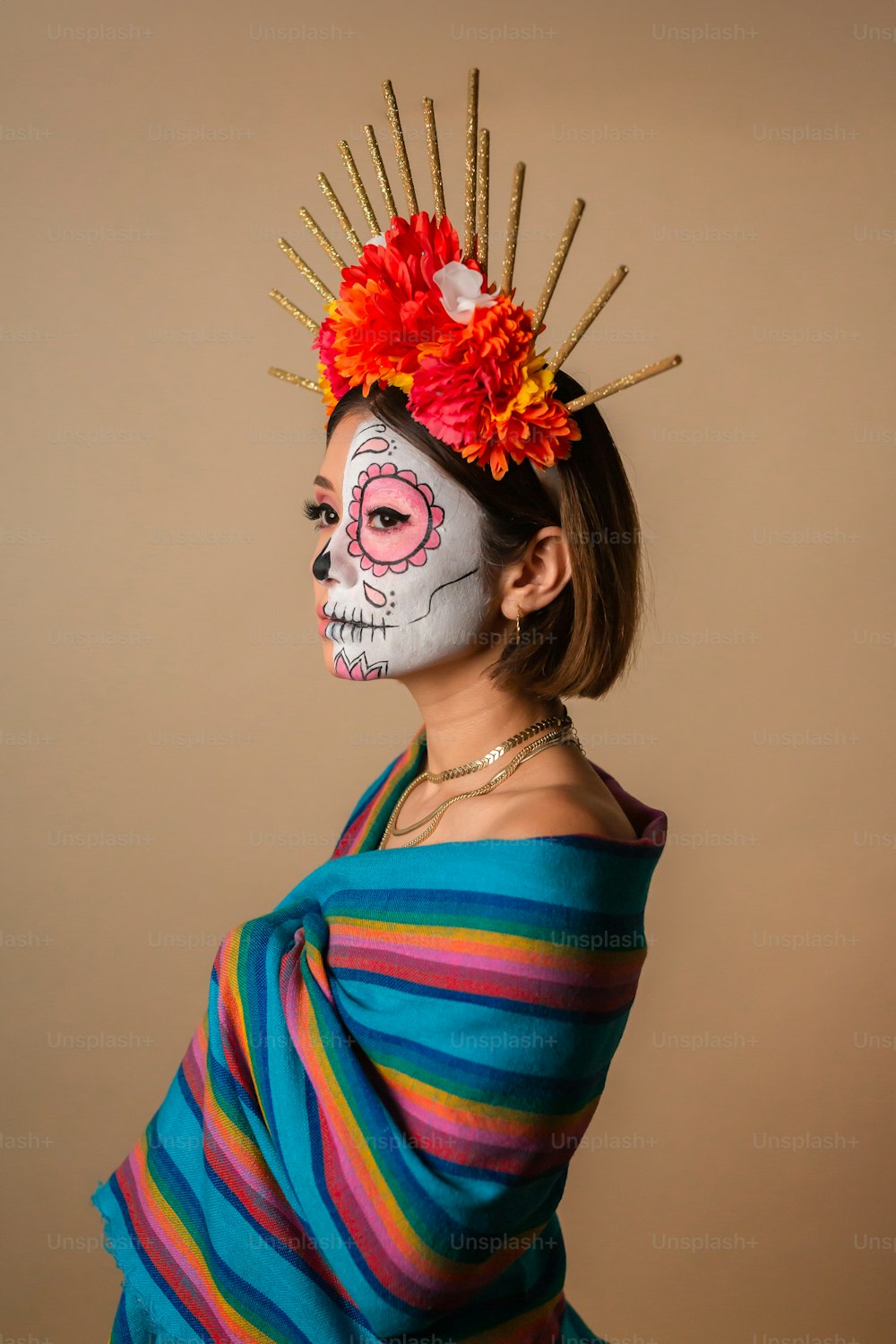Una mujer con una cara pintada de esqueleto y una flor en el pelo