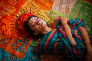 a woman laying on top of a colorful blanket