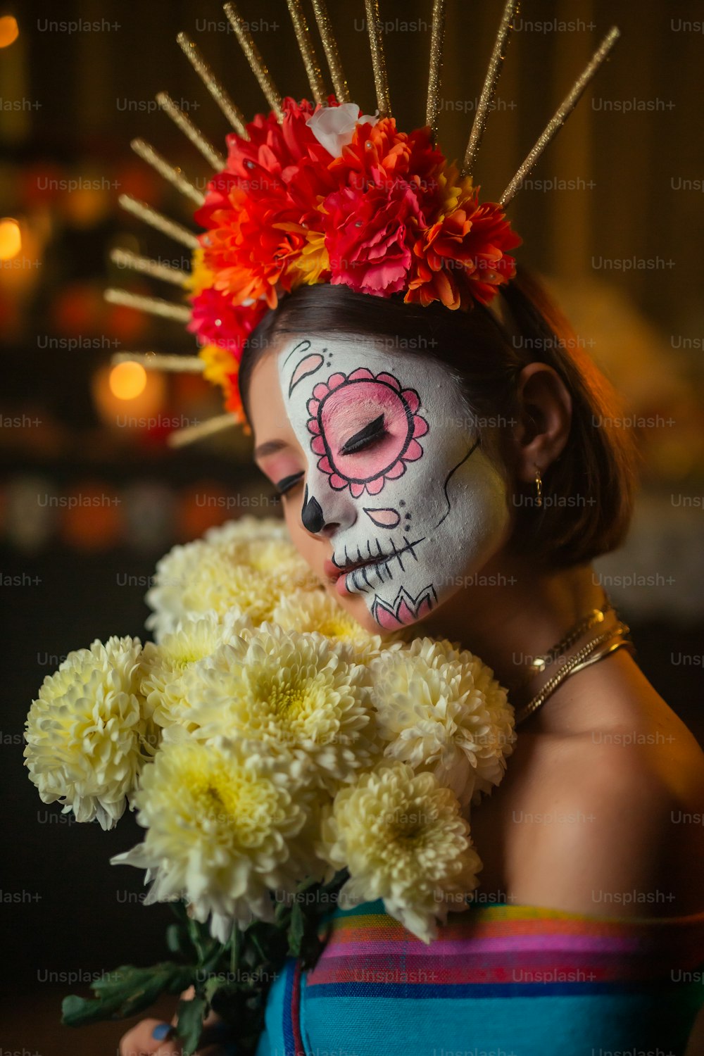 Eine Frau mit einem Totenkopf im Gesicht, der einen Blumenstrauß hält