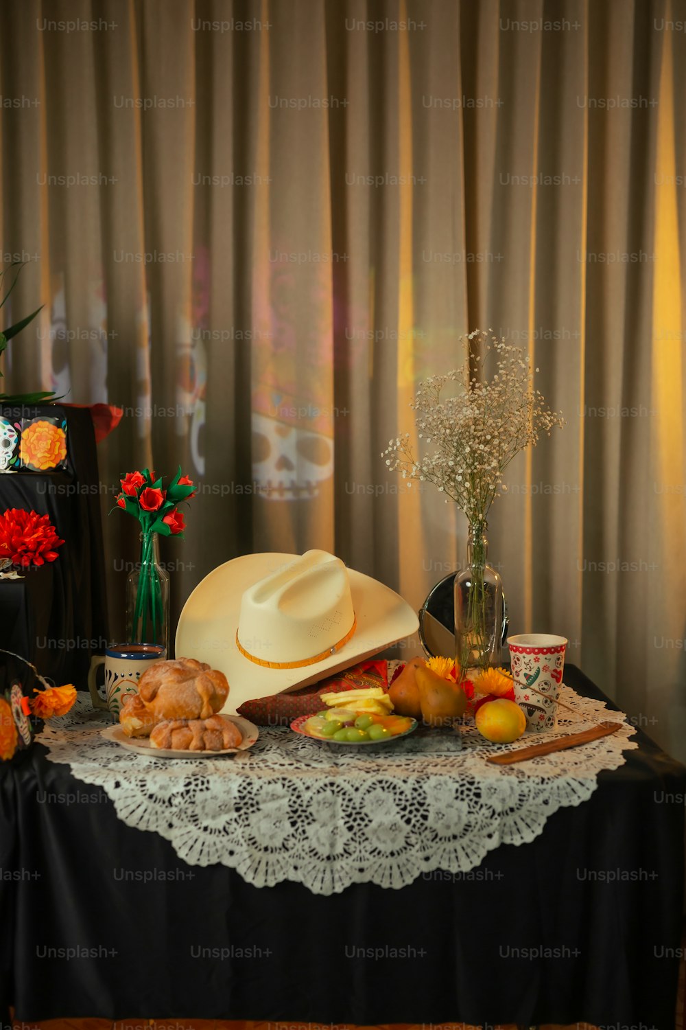 a table topped with a hat and a bunch of fruit