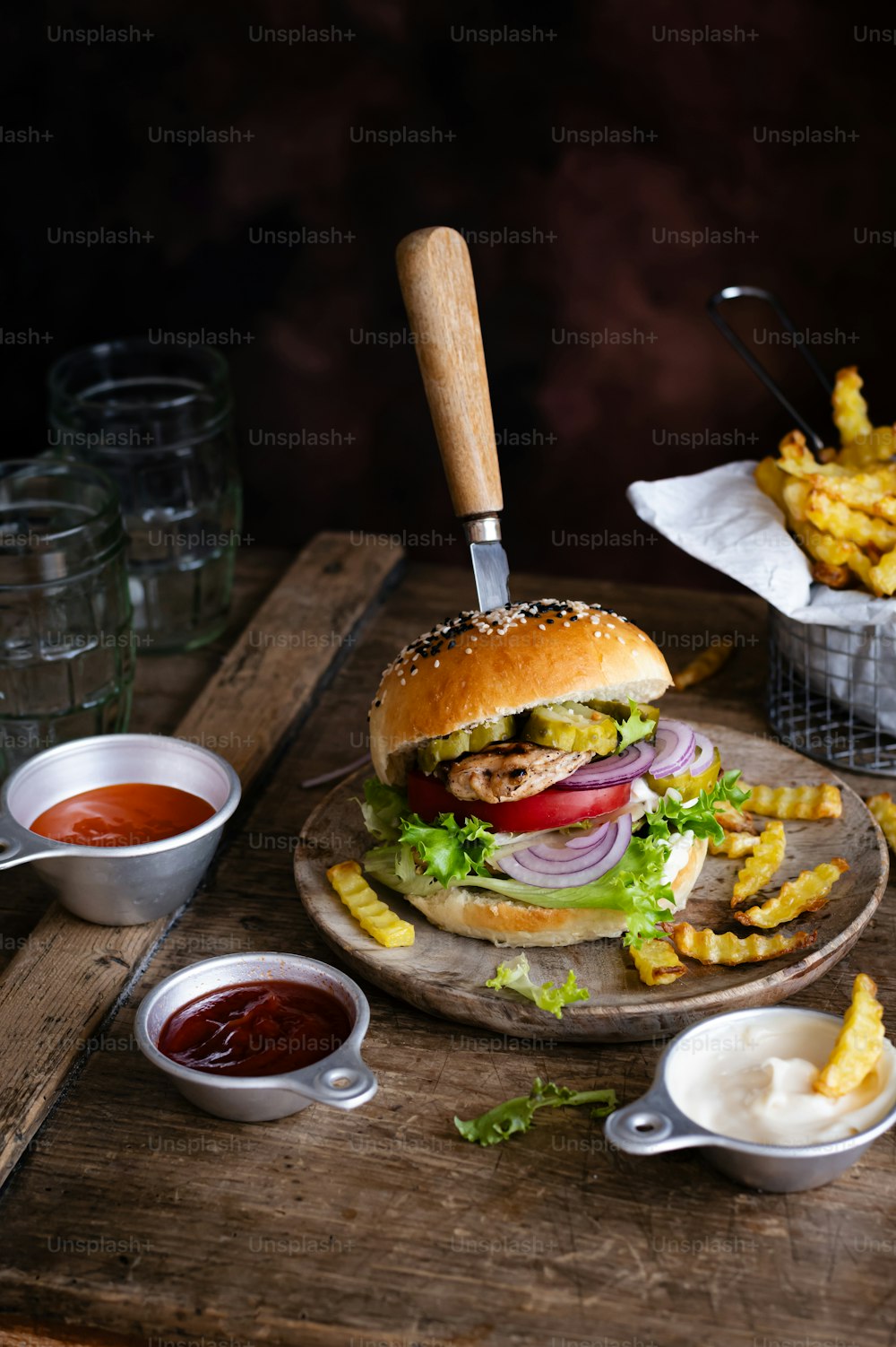a hamburger with fries and ketchup on a wooden tray