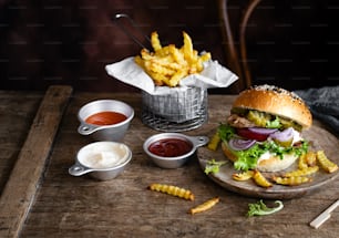 a hamburger with fries and ketchup on a wooden tray