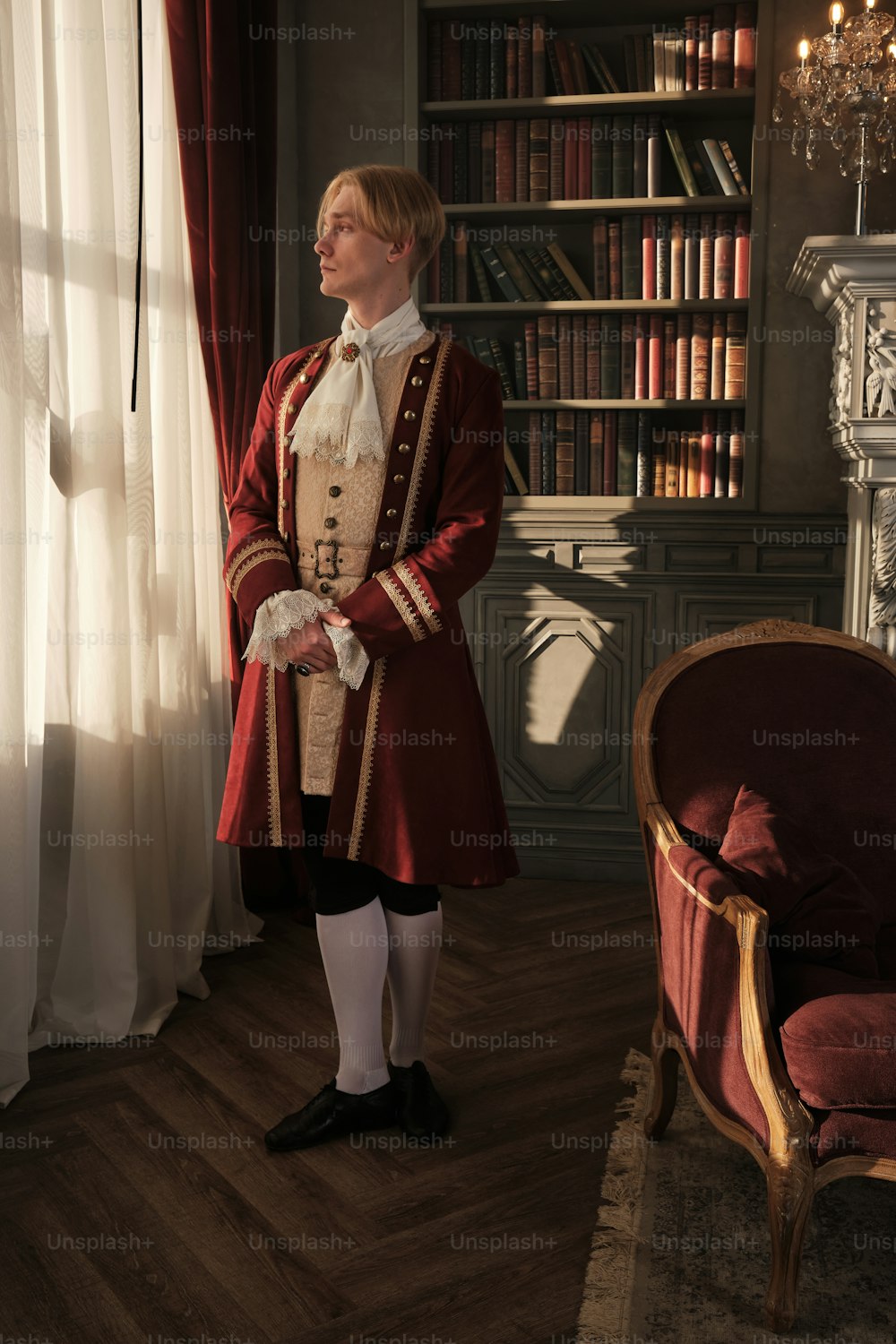 a man in a red uniform standing in front of a window