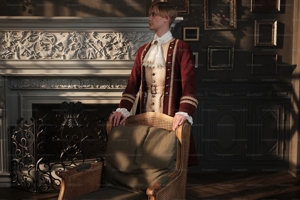 a man in a red and white suit standing next to a fireplace