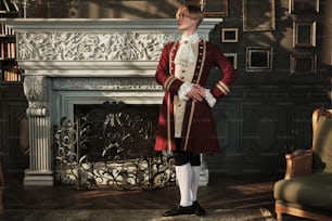 a man in a red uniform standing in front of a fireplace