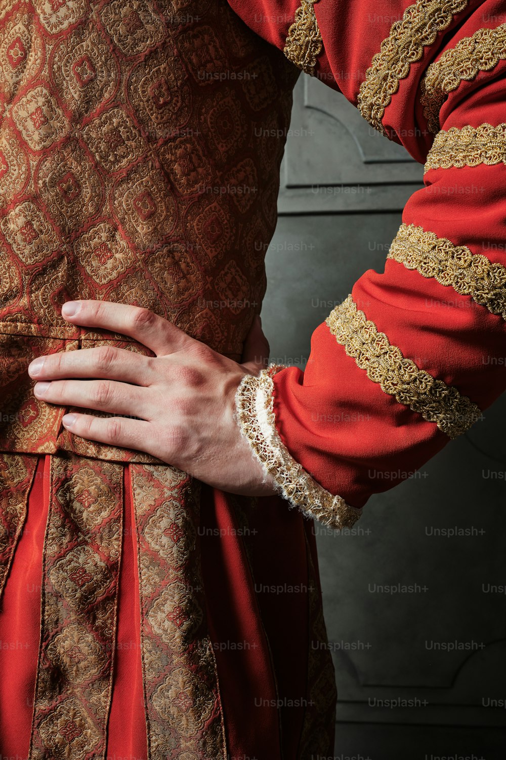 a close up of a person wearing a red and gold dress