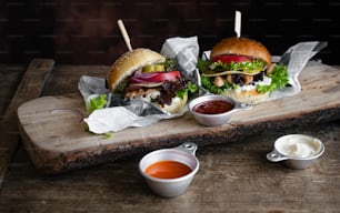 a wooden cutting board topped with two sandwiches