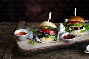 a couple of sandwiches sitting on top of a wooden cutting board