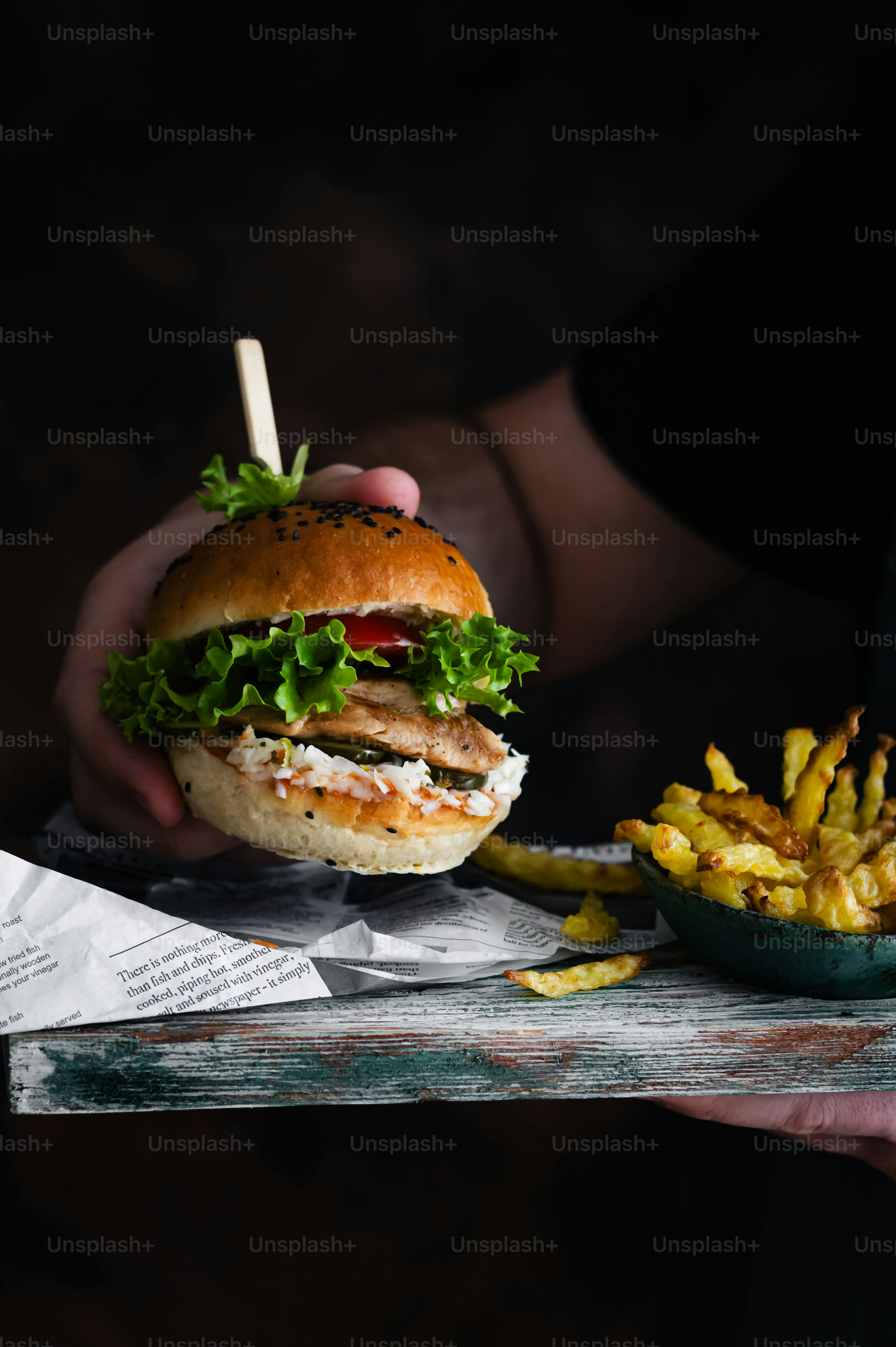 a person holding a sandwich and french fries