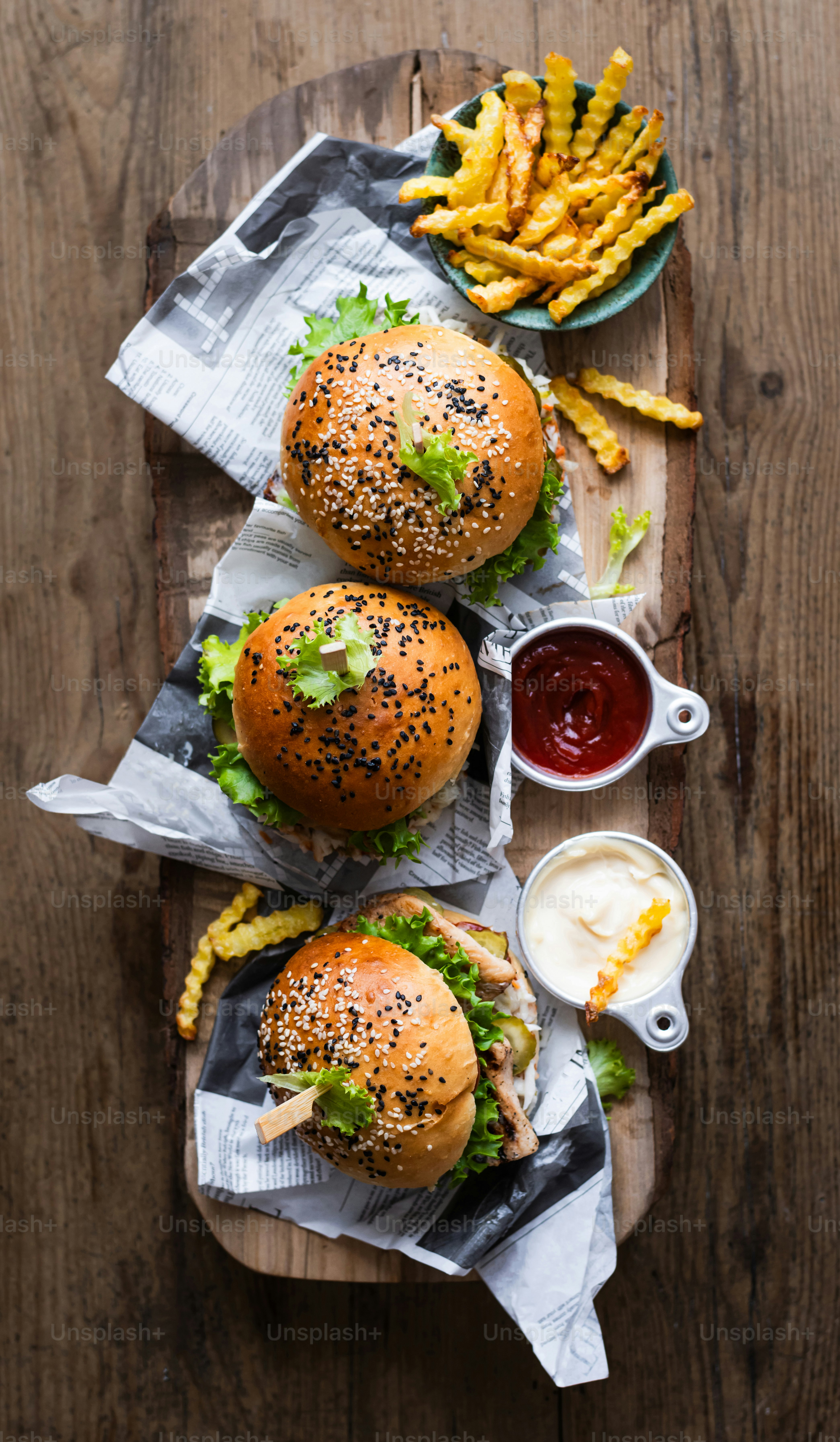 ein Holztablett mit zwei Burgern und Pommes Frites