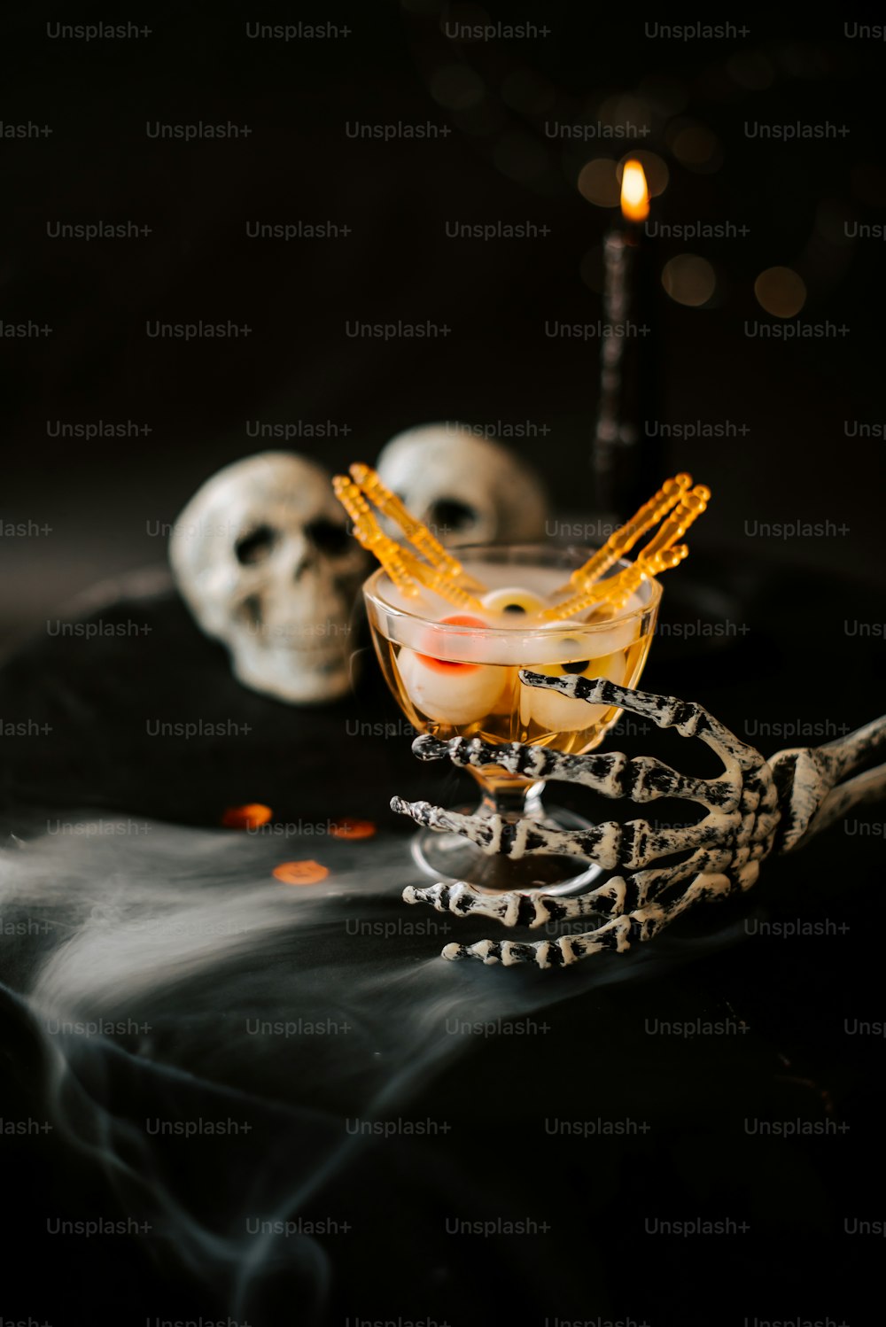 a halloween drink with a skeleton decoration and a candle