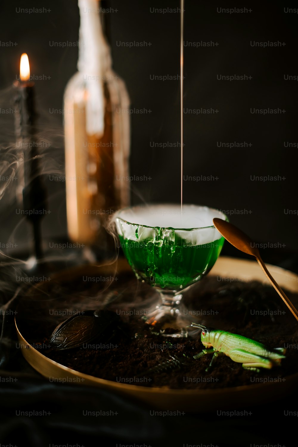 a green liquid in a glass on a plate