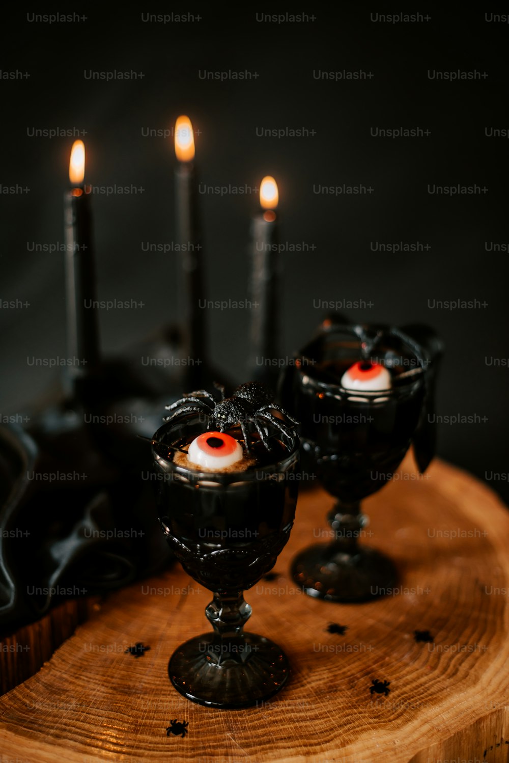 a couple of black candles sitting on top of a wooden table