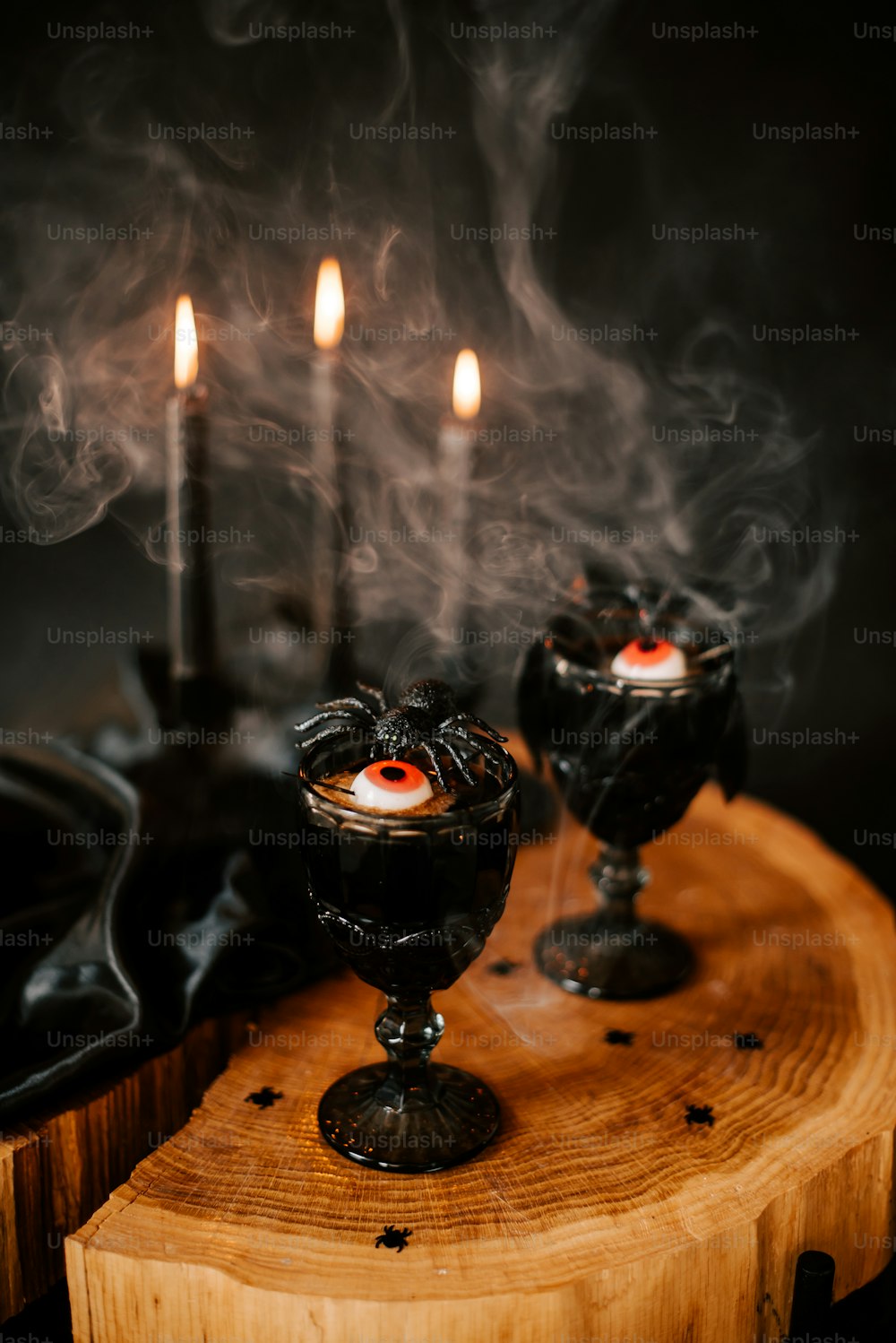 a wooden table topped with two black candles