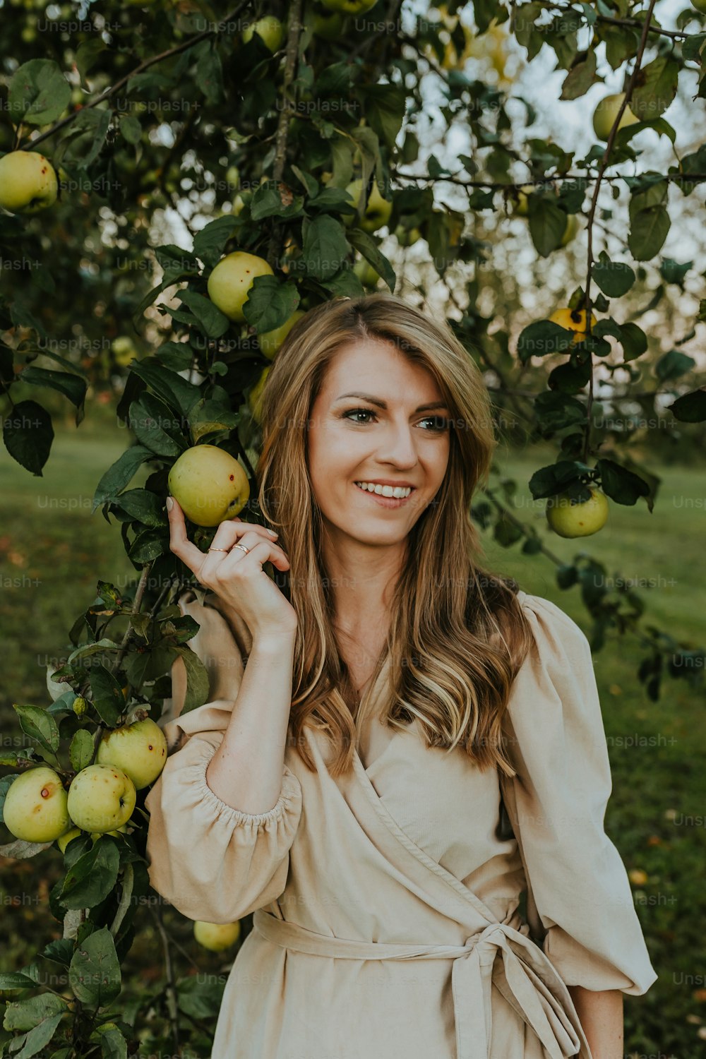 a woman in a dress standing under a tree