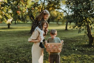 a woman holding a basket next to two children