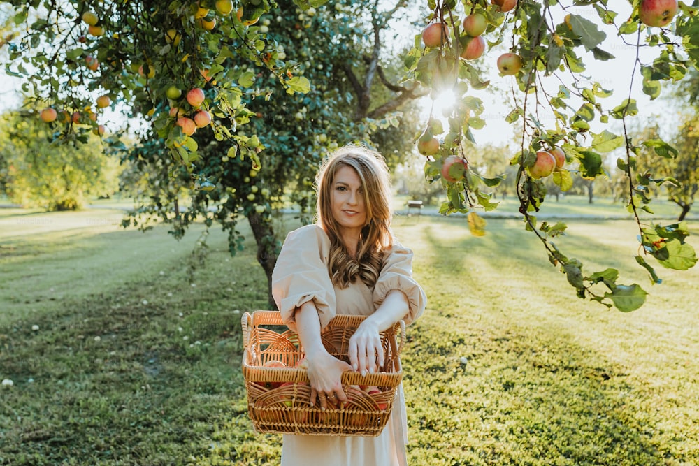 a woman holding a basket under a tree