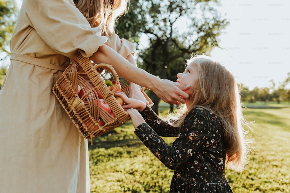 a woman holding a child's hand near a basket