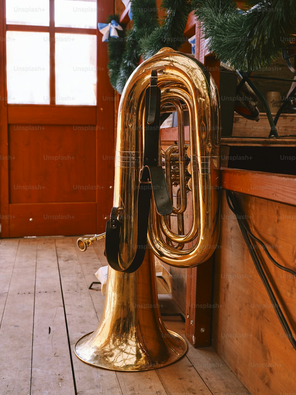 Una trompeta de bronce sentada encima de un piso de madera