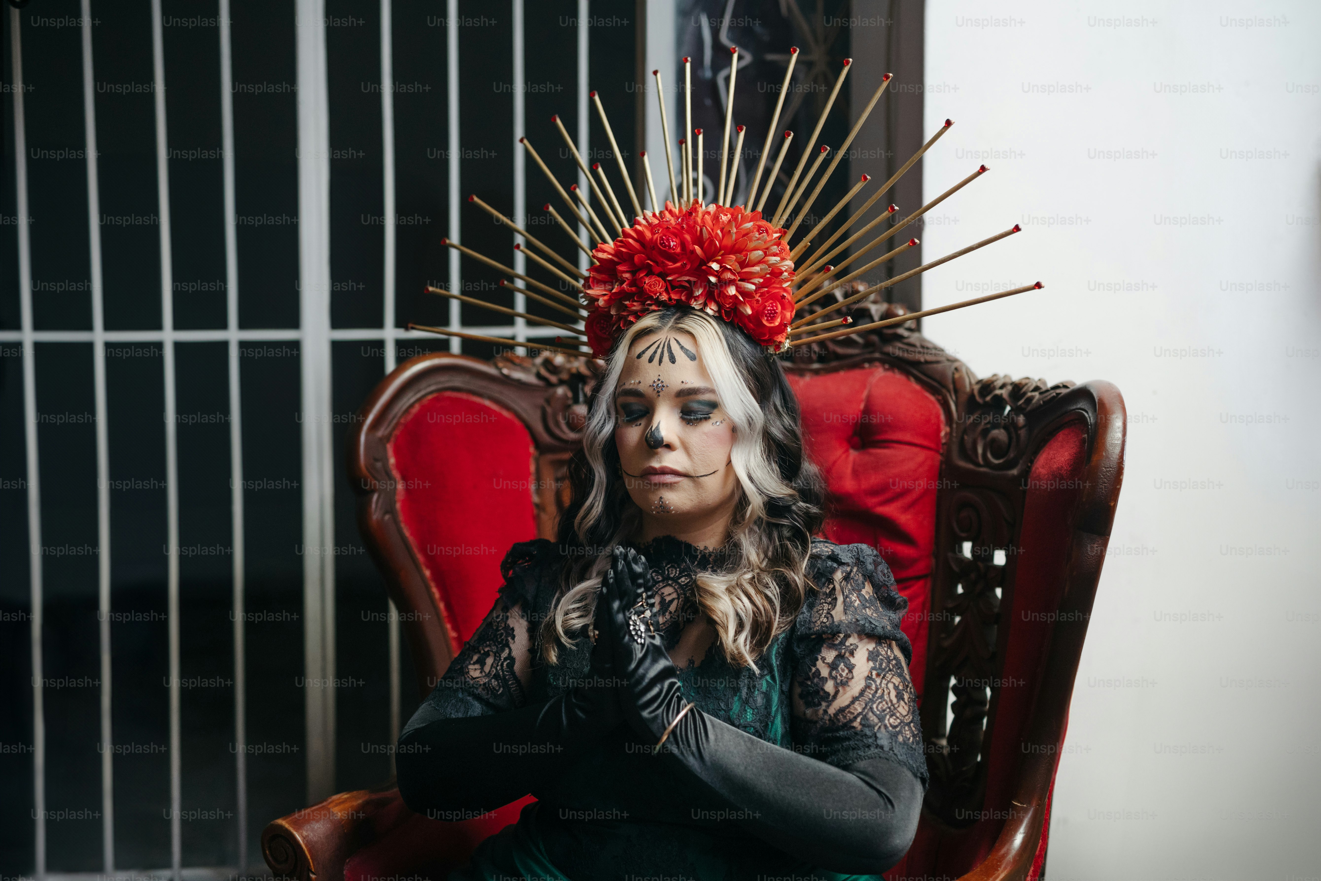 a woman sitting in a chair with a red head piece on her head