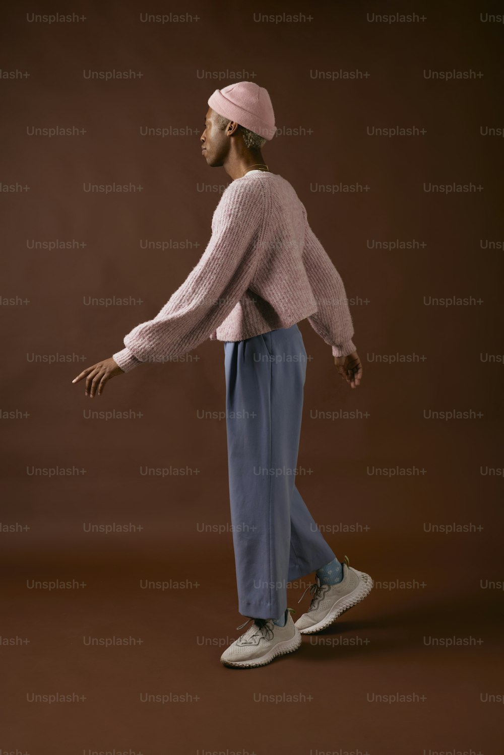 a woman in a pink sweater and blue pants