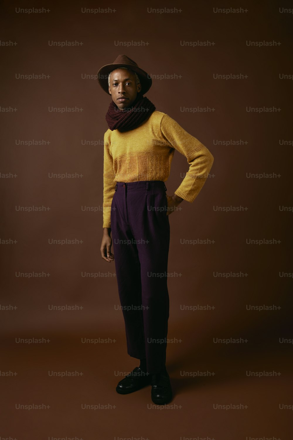 a man in a yellow sweater and purple pants