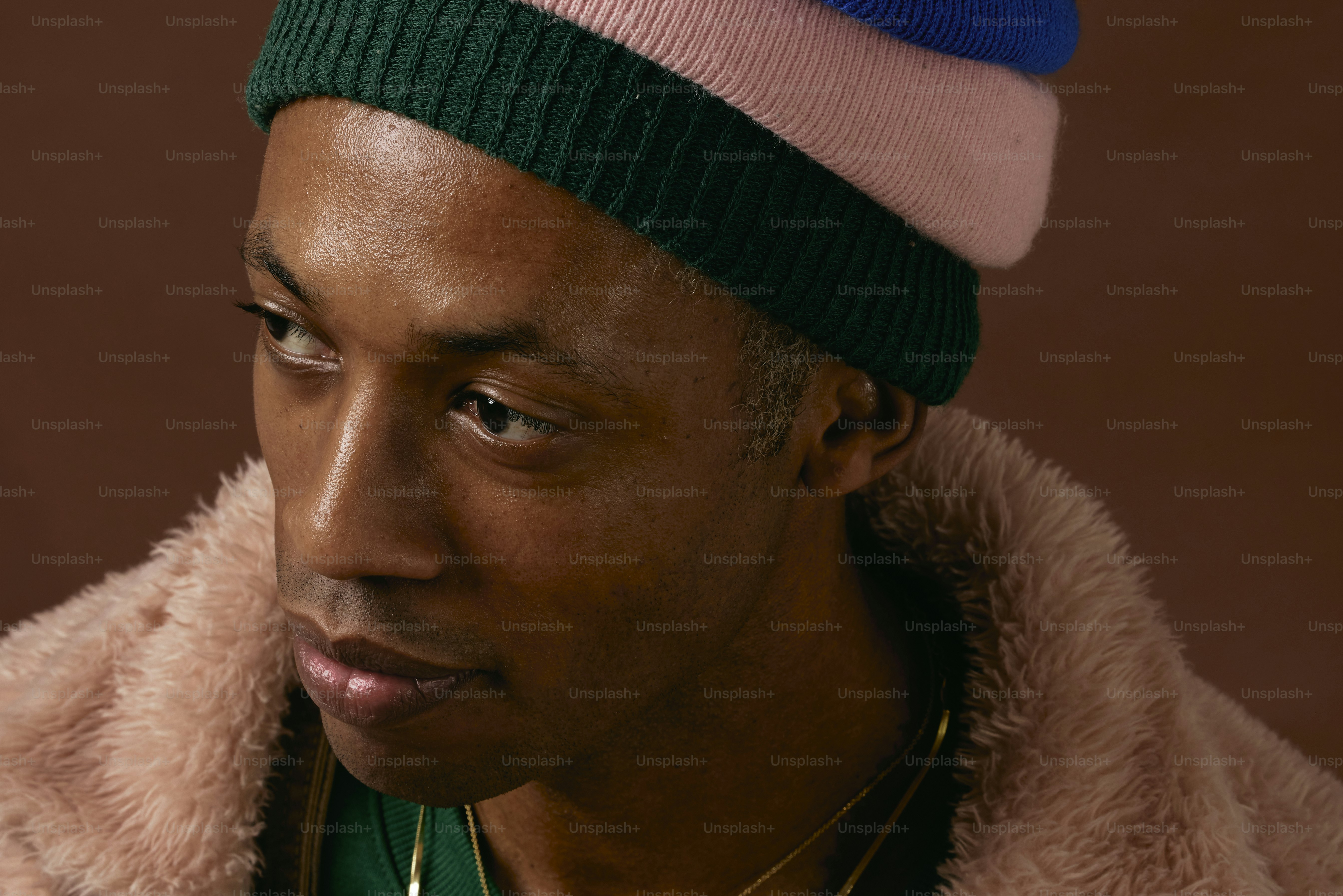 a man wearing a pink, green, and blue hat