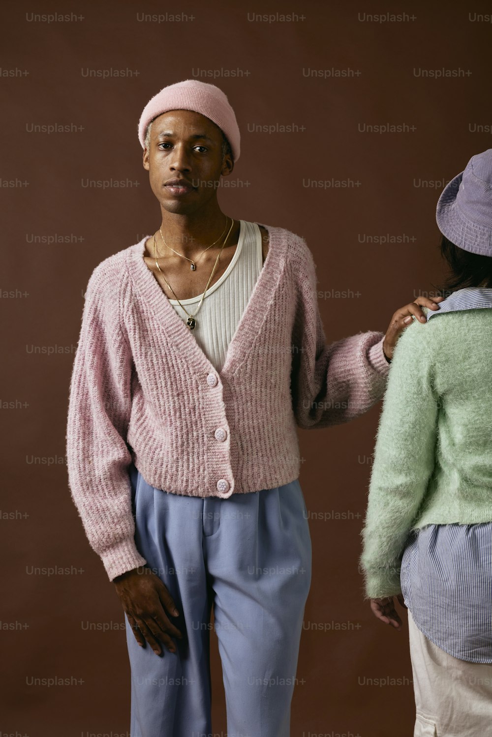 a woman standing next to another woman in a pink sweater