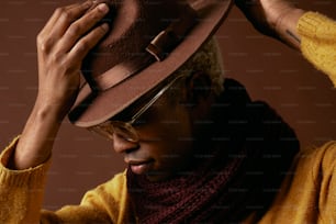 Un homme portant un chapeau brun et un foulard