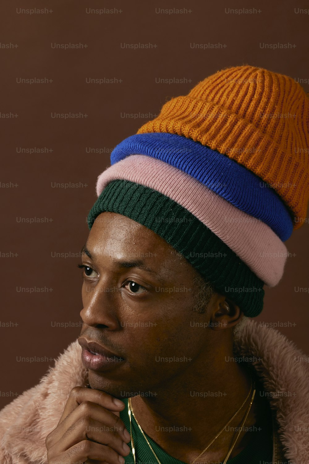 a man wearing a multicolored hat and a fur coat