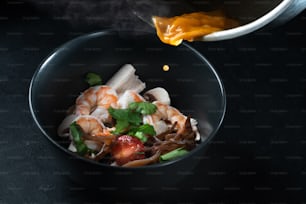 a bowl of noodles with shrimp and vegetables