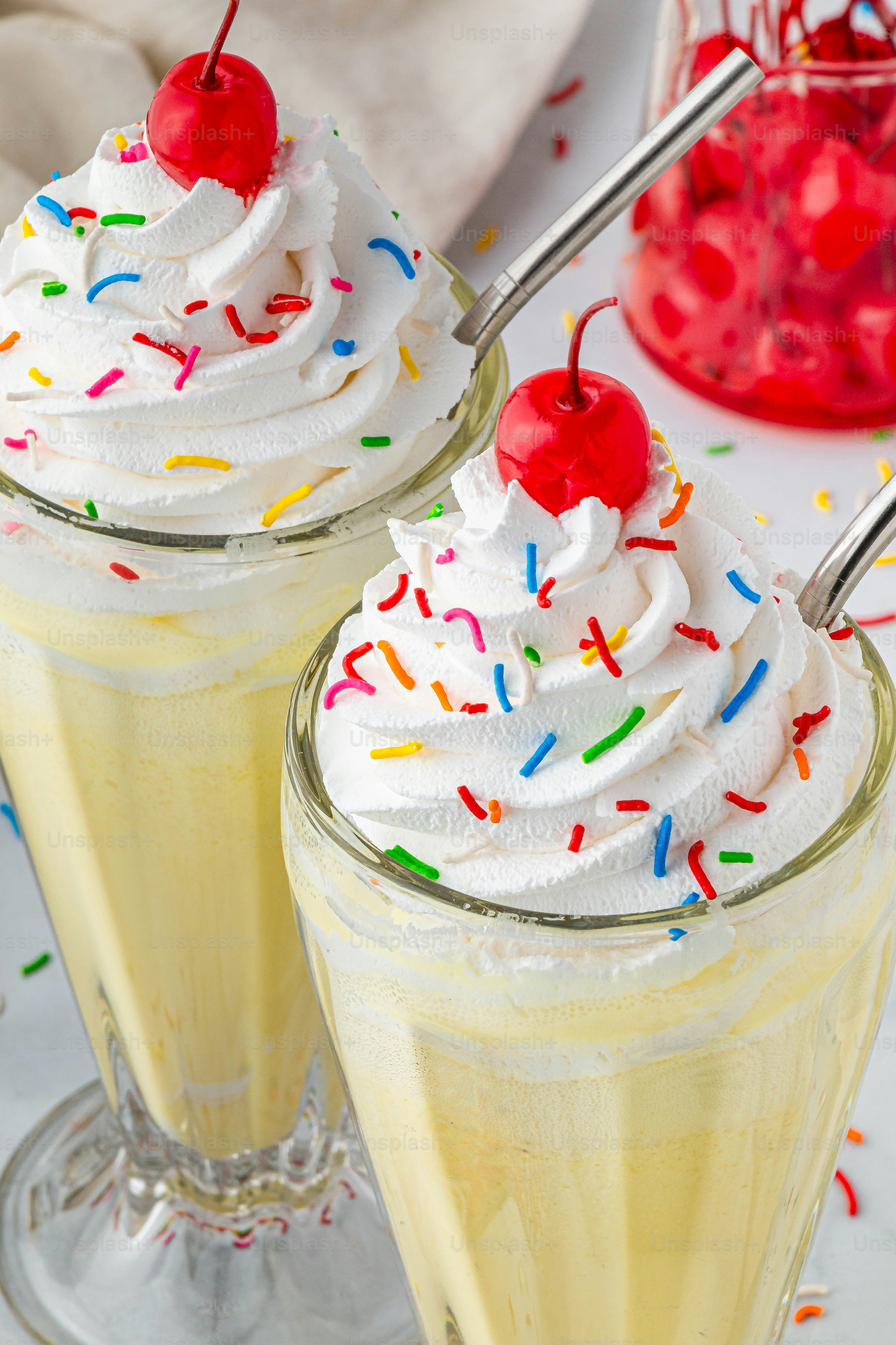 Zwei Gläser Eis mit Streuseln und Kirschen