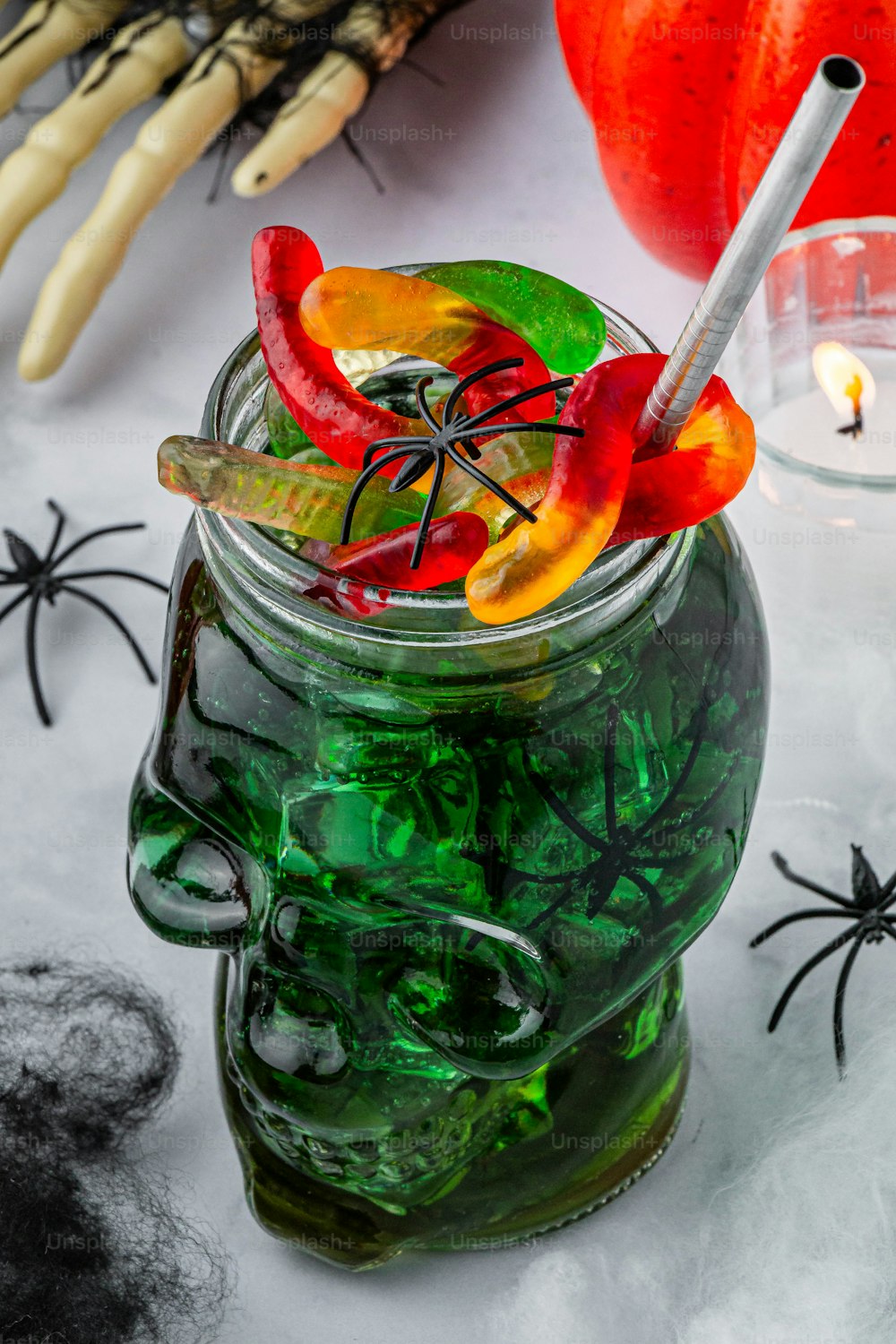 a glass jar filled with green liquid and halloween decorations