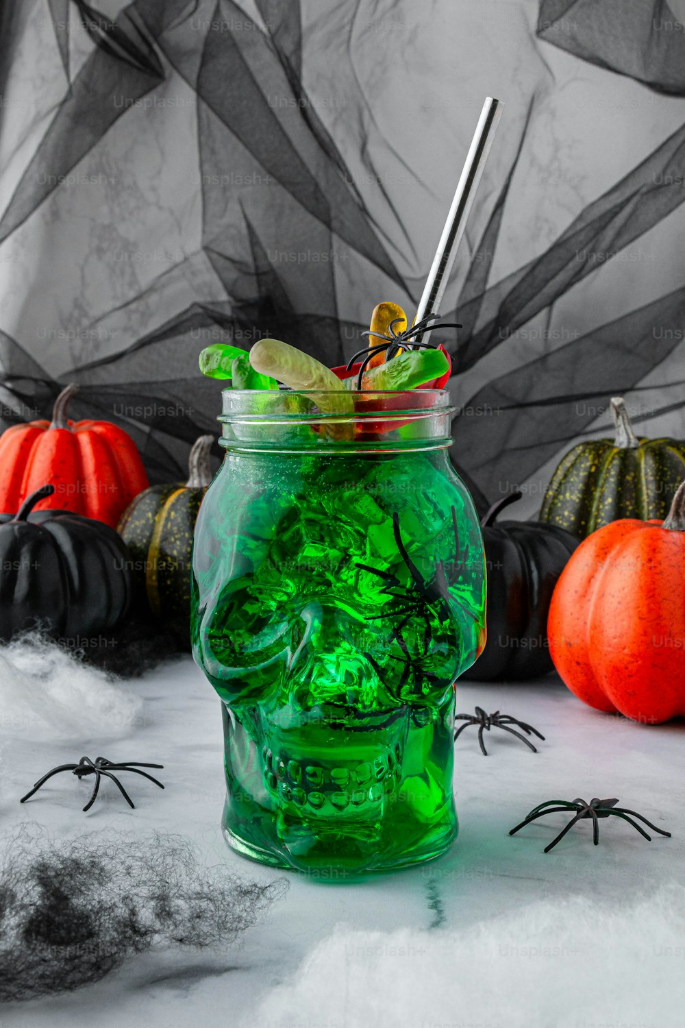 a jar filled with green liquid and halloween decorations