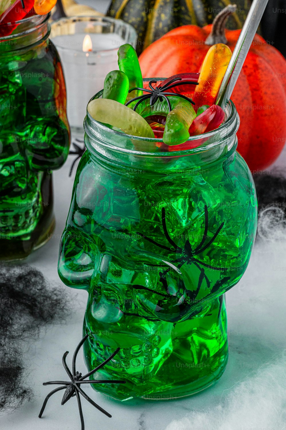 a green jar filled with candy and halloween decorations