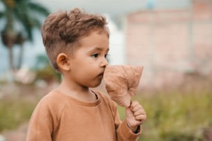 a little boy holding a piece of wood in his mouth