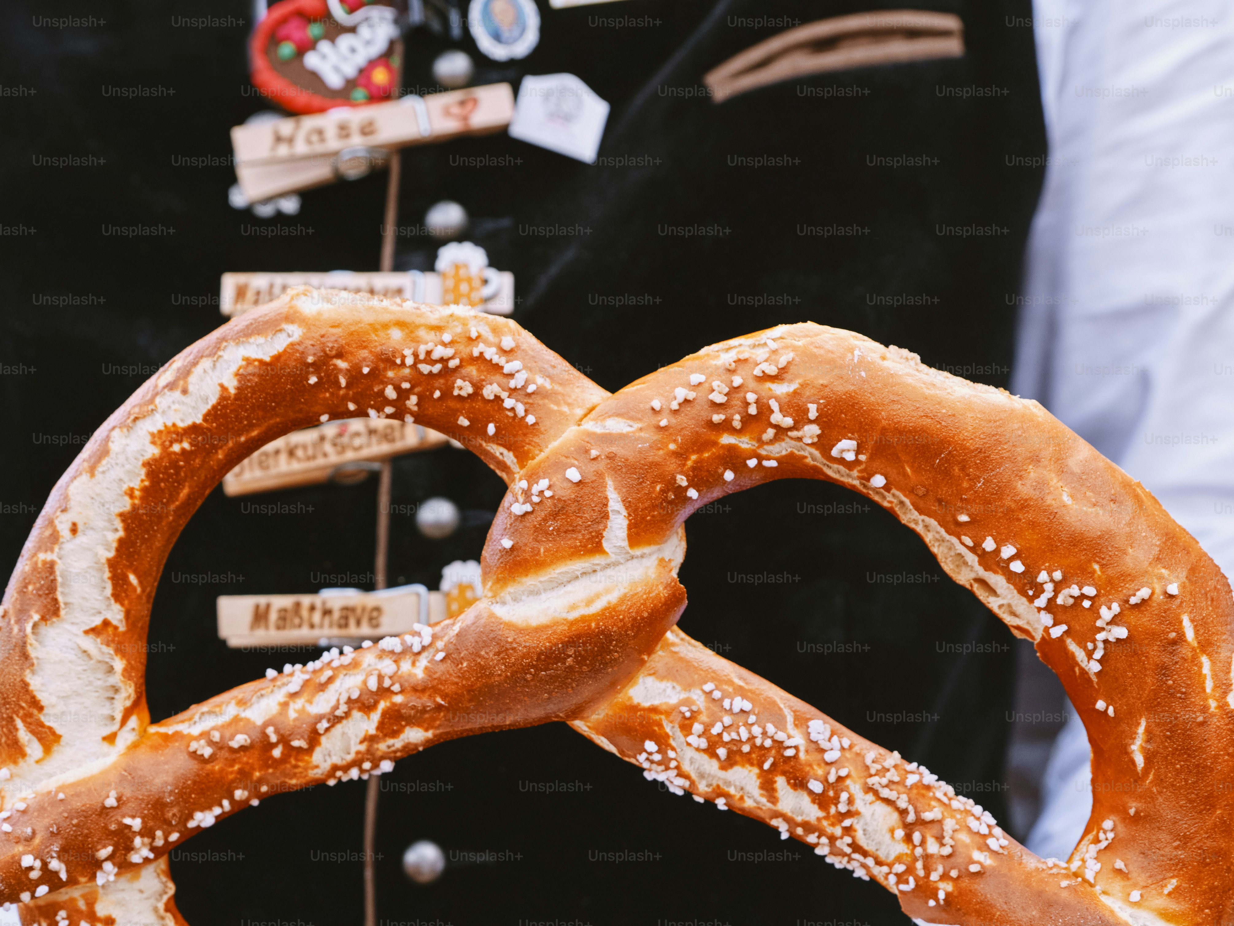 제복을 입은 남자가 들고 있는 큰 프레첼