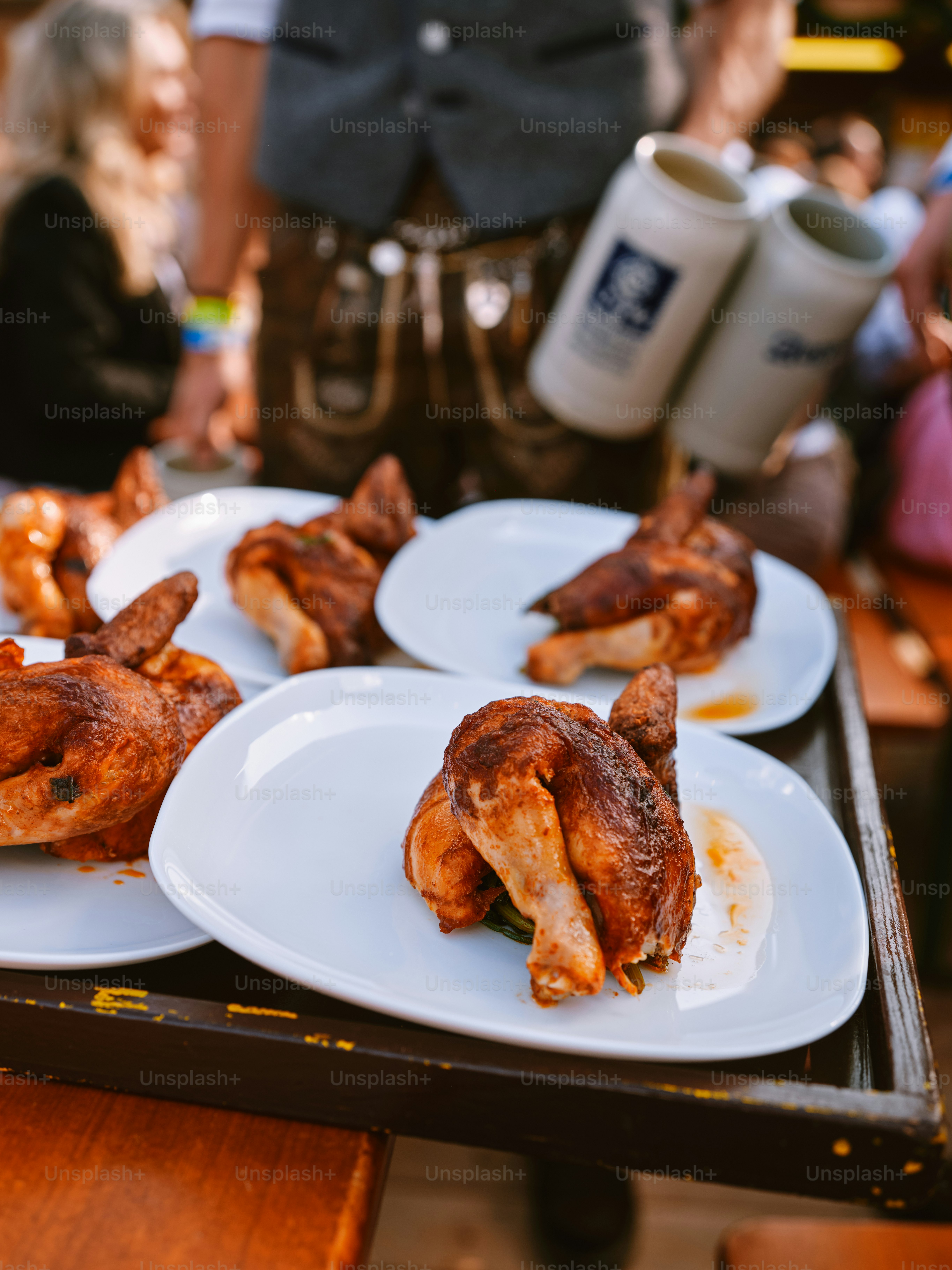 three plates of food on a table with people in the background