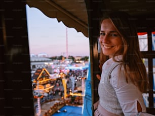 a woman standing in front of a window with a view of a carnival