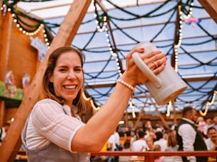 a woman holding up a cup in front of a crowd