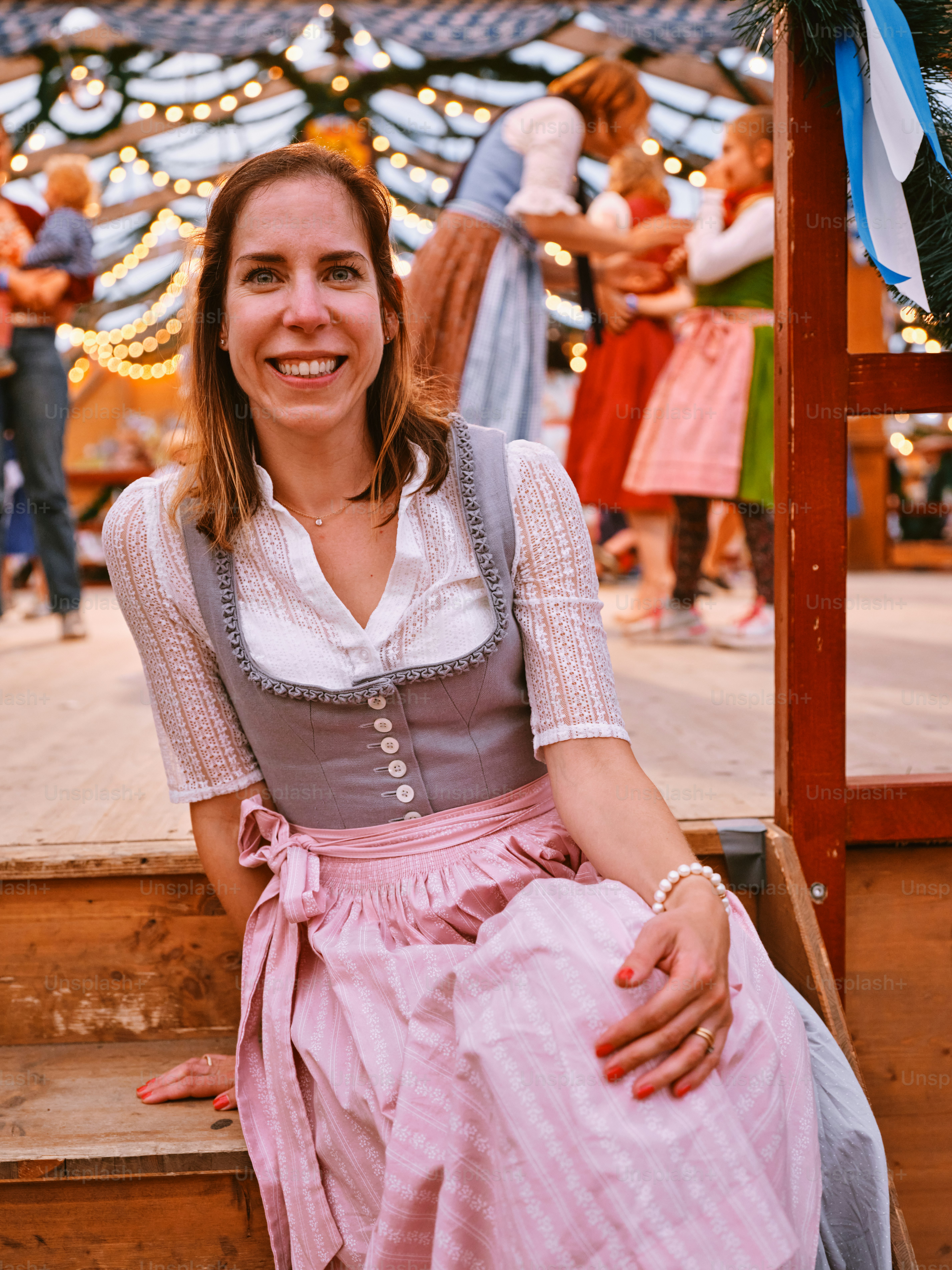 a woman in a pink dress sitting on a step