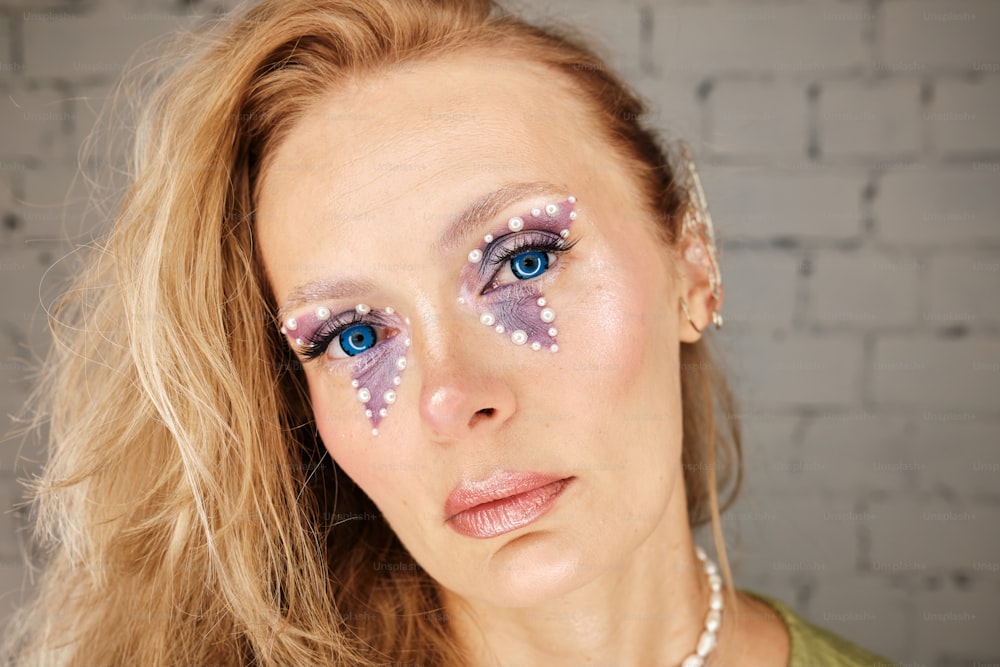 a woman with blue eyes and white polka dots on her face