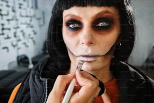 a woman with makeup on her face is holding a toothbrush