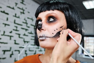 a woman with black hair and a skeleton make up