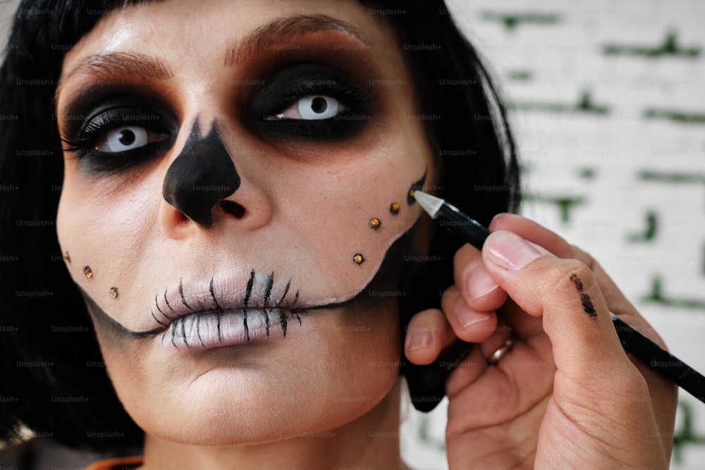 eine Frau mit schwarzem Make-up und einem Skelett-Make-up