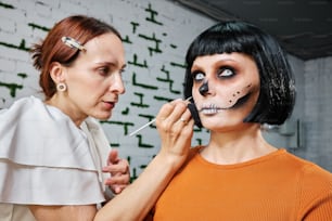 a woman is putting makeup on a woman's face